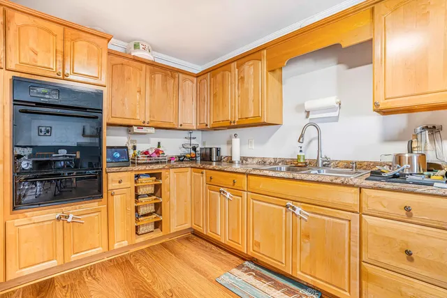 a kitchen with granite countertop a sink stainless steel appliances and cabinets