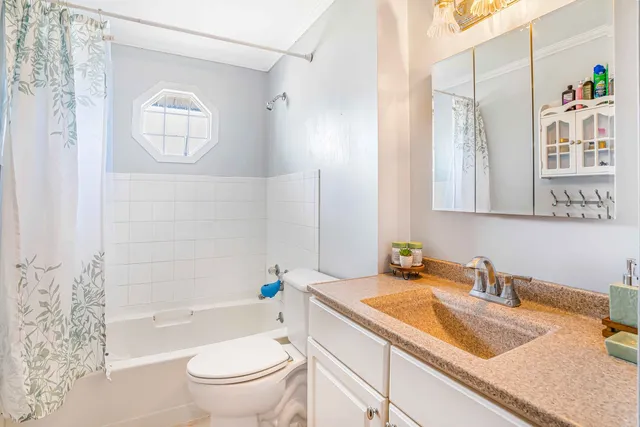 a bathroom with a granite countertop sink toilet a mirror and shower