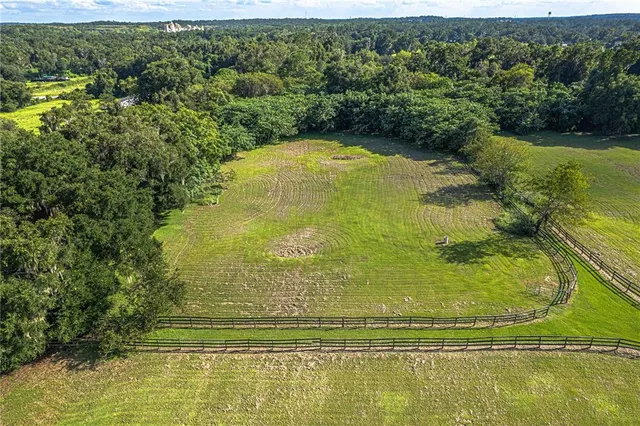 an aerial view of a houses with outdoor space swimming pool and mountain view in back