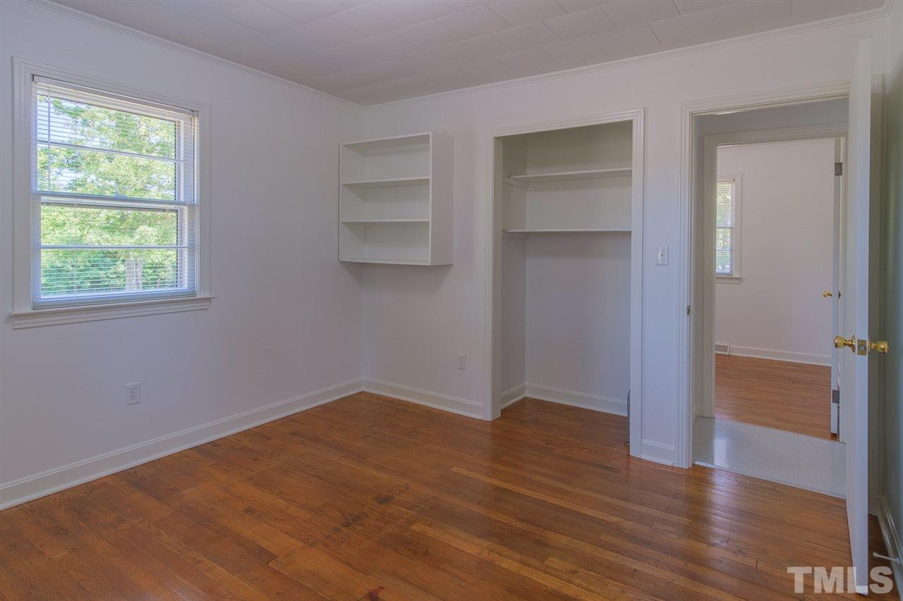 1301 Royster Clay Road Roxboro, NC 27574 - Photo 15 of 30 an empty room with wooden floor closet and windows