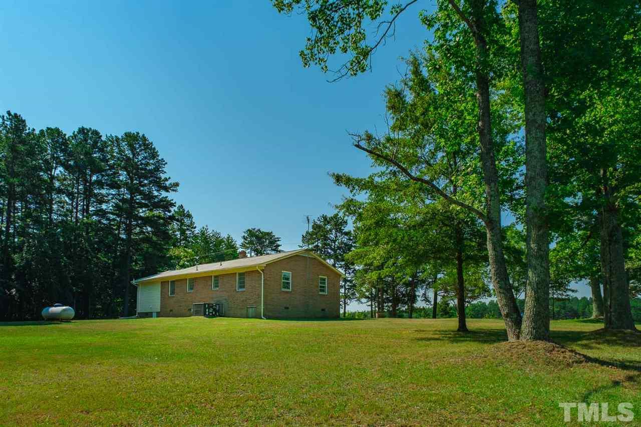 1301 Royster Clay Road Roxboro, NC 27574 - Photo 3 of 30 a front view of a house with a yard and trees