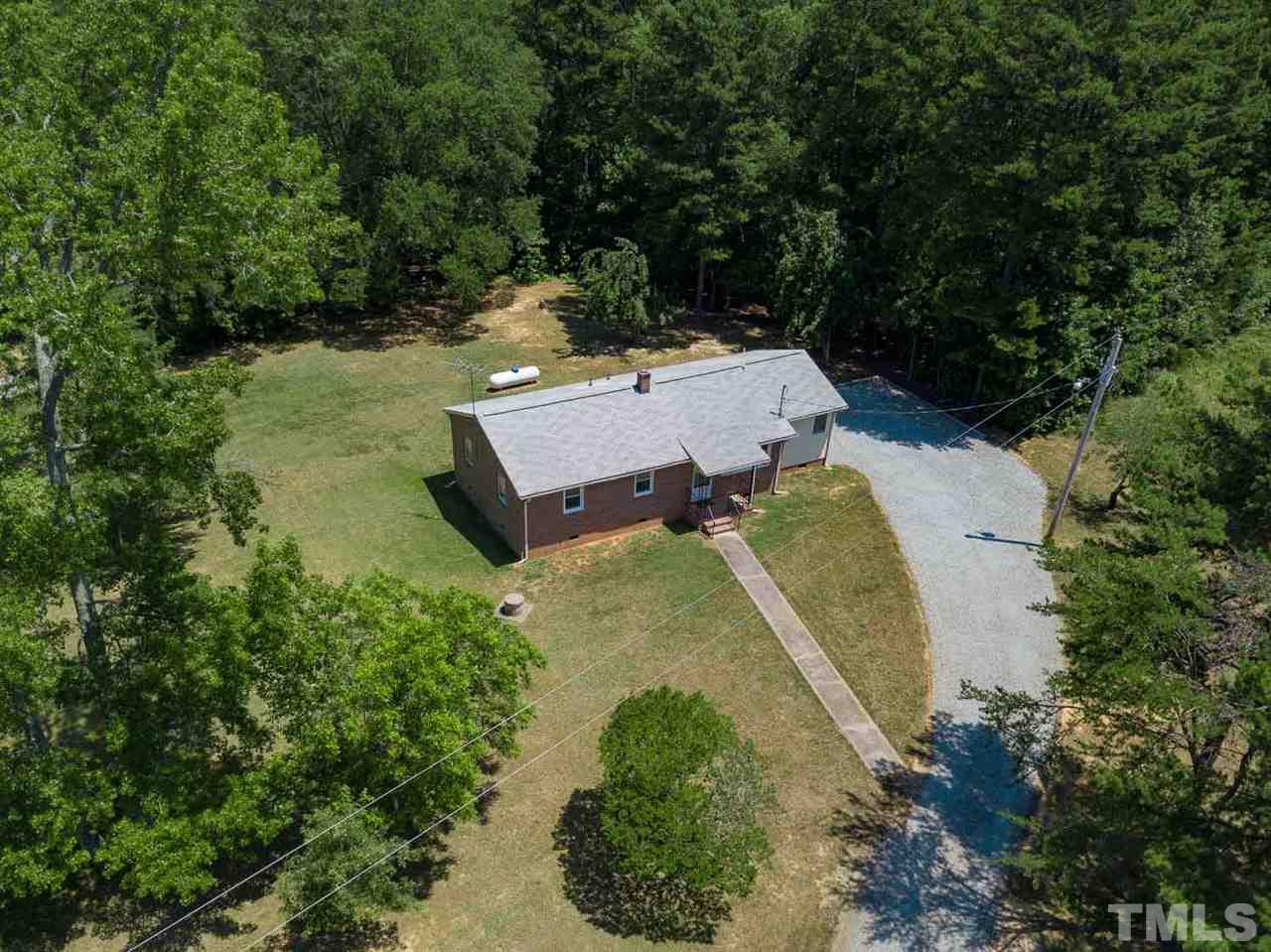 1301 Royster Clay Road Roxboro, NC 27574 - Photo 22 of 30 an aerial view of a house with a yard and large trees