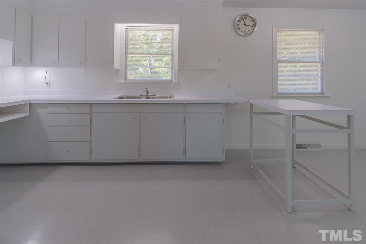 1301 Royster Clay Road Roxboro, NC 27574 - Photo 10 of 30 a kitchen with white cabinets and a window