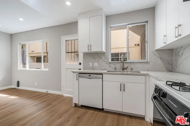 a kitchen with granite countertop white cabinets and white appliances