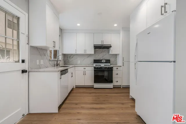 a kitchen with a refrigerator and a stove top oven