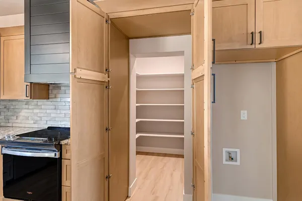 a view of a big room with wooden floor and a kitchen