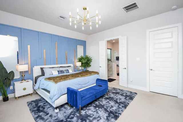 a spacious bedroom with a bed and a chandelier