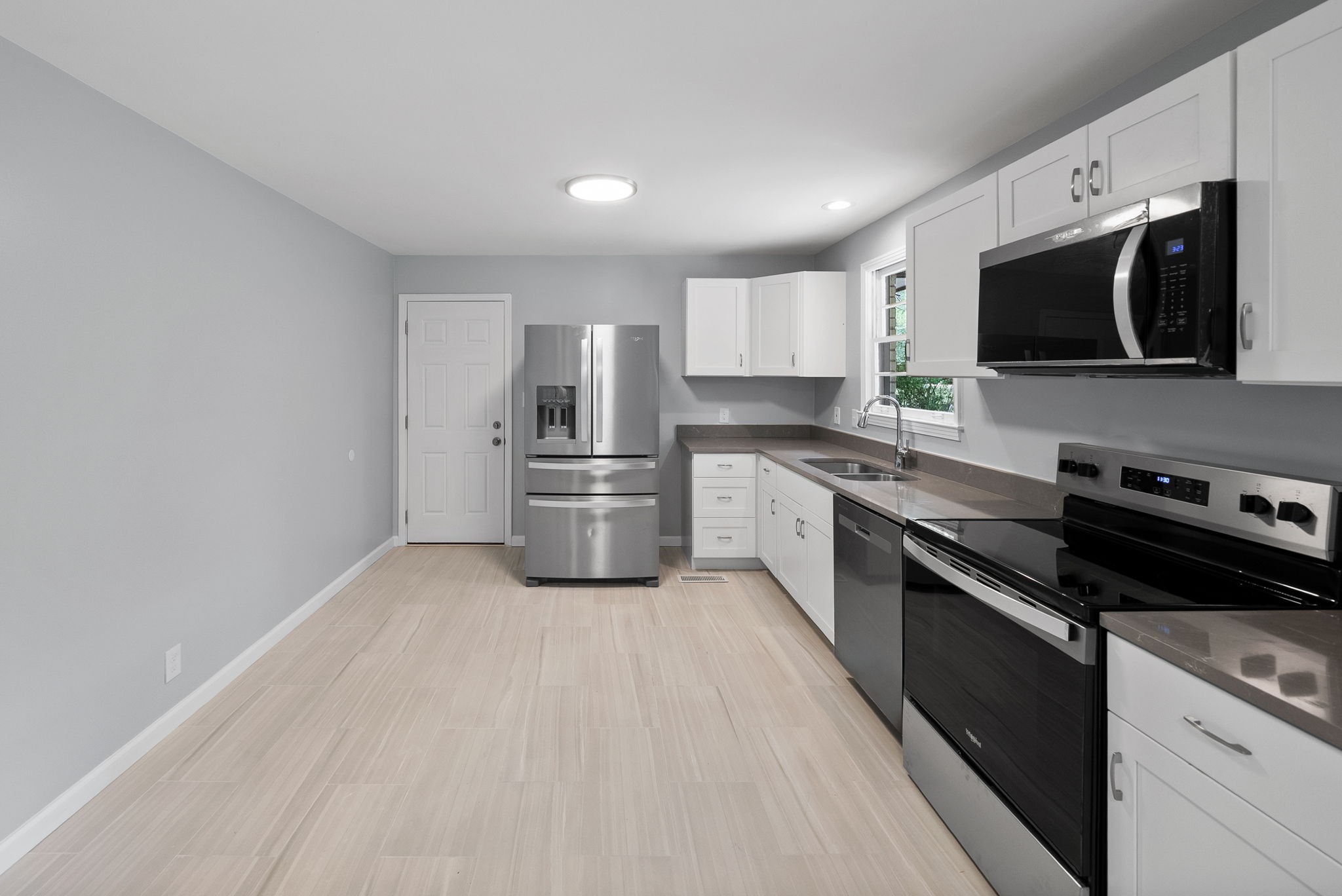 511 Ruby Drive Clarksville, TN 37040 - Photo 9 of 28 a kitchen with stainless steel appliances a sink dishwasher a refrigerator and a stove top oven with wooden floor