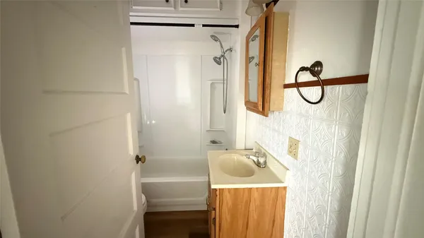 a bathroom with a granite countertop shower a mirror and a sink