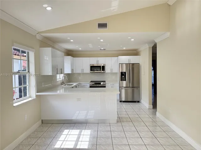 a kitchen with stainless steel appliances a refrigerator sink and microwave