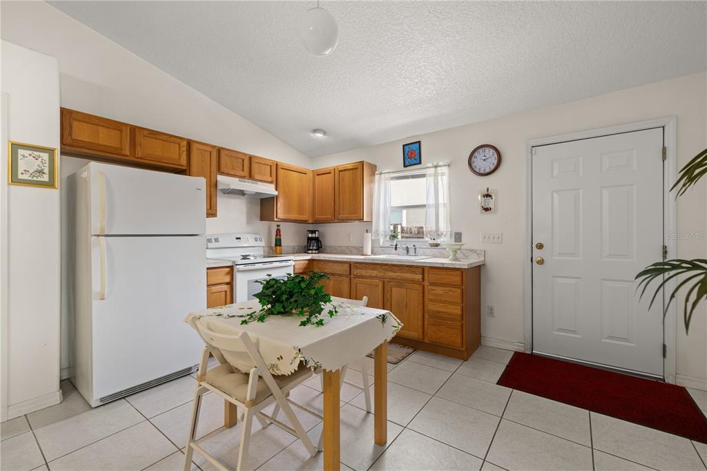 6907 Log Jam Court Ocoee, FL 34761 - Photo 19 of 30 a kitchen with stainless steel appliances kitchen island granite countertop a refrigerator and a stove top oven