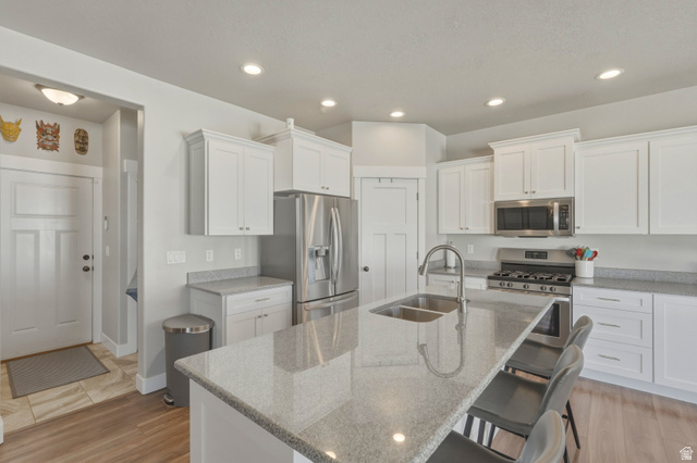 836 South 250 West Vernal, UT 84078 - Photo 23 of 56 Kitchen with white cabinets, stainless steel appliances, light stone counters, a center island with sink, and recessed lighting