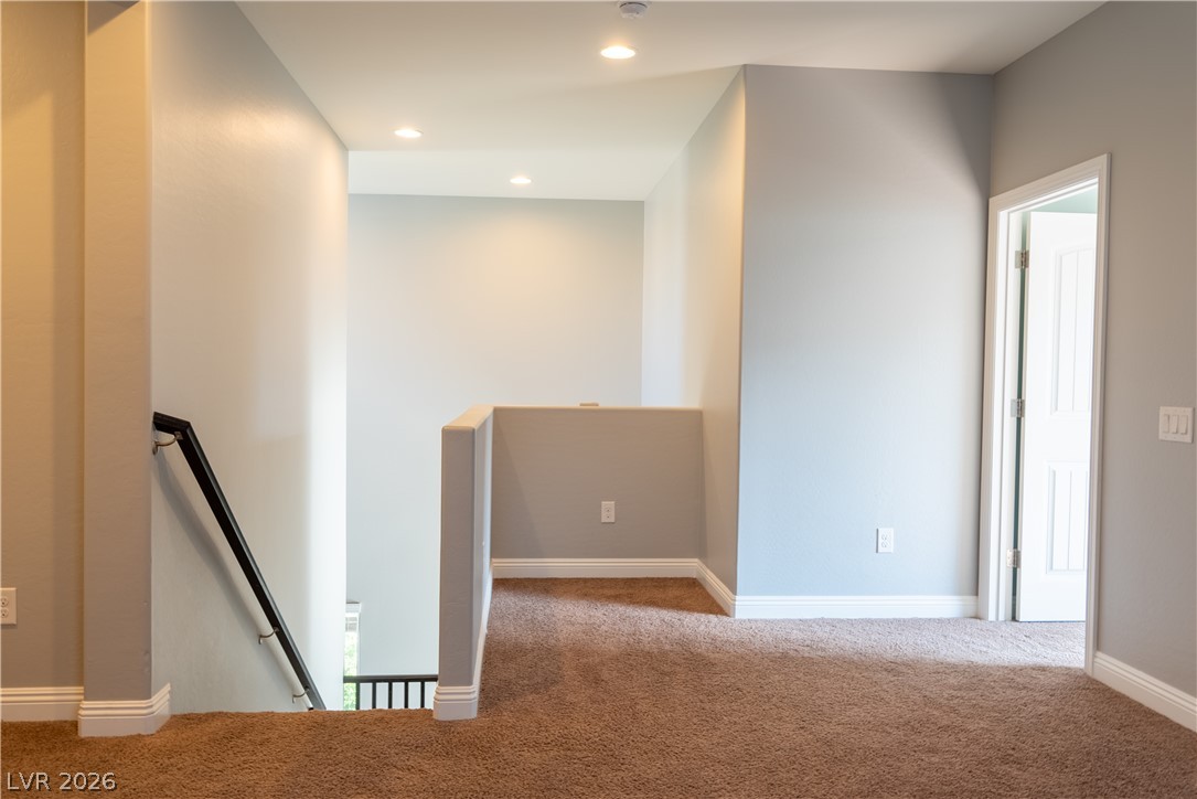 11045 Elk Sands Road Las Vegas, NV 89179 - Photo 20 of 67 A spacious upper-level landing features soft carpeting, recessed lighting, and a view of the stairs.
