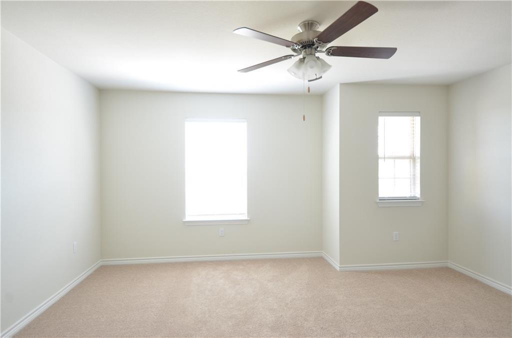14403 McCoy Loop Austin, TX 78717 - Photo 19 of 29 A well-lit bedroom features plush carpeting and two windows, offering a bright and comfortable retreat.
