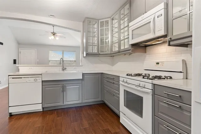 a kitchen with stainless steel appliances granite countertop a sink and cabinets with wooden floors