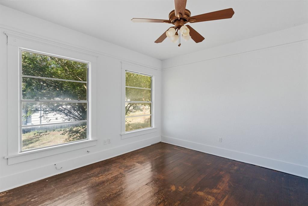 709 East 23rd Street Cisco, TX 76437 - Photo 14 of 17 an empty room with wooden floor fan and windows