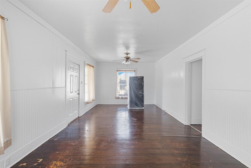 709 East 23rd Street Cisco, TX 76437 - Photo 5 of 17 an empty room with wooden floor chandelier and windows