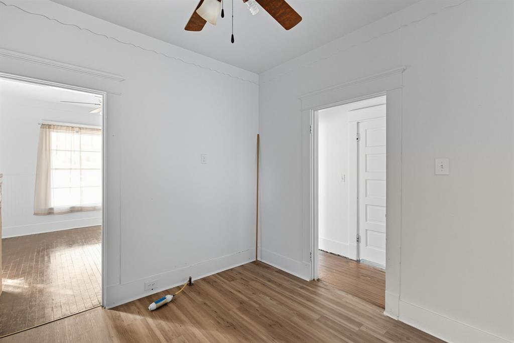 709 East 23rd Street Cisco, TX 76437 - Photo 7 of 17 an empty room with wooden floor and windows