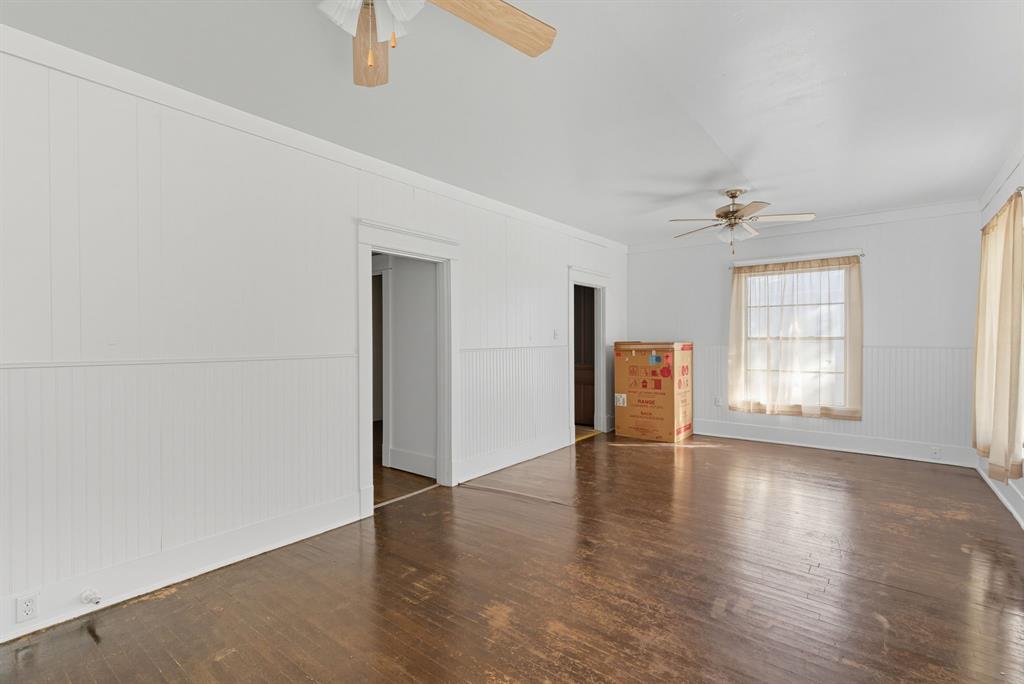 709 East 23rd Street Cisco, TX 76437 - Photo 9 of 17 an empty room with wooden floor and windows