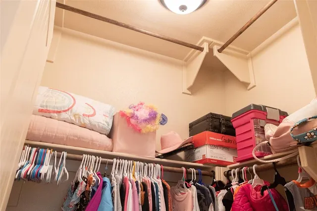 a view of walk in closet with clothes and shoes