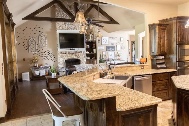 a living room with stainless steel appliances kitchen island granite countertop a dining table and chairs