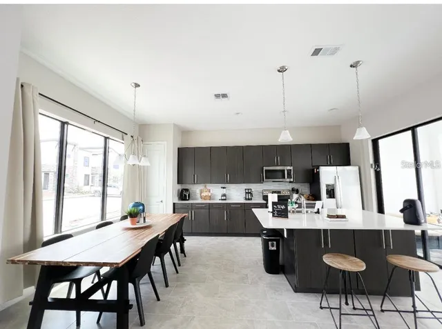 a kitchen with a dining table chairs and view living room