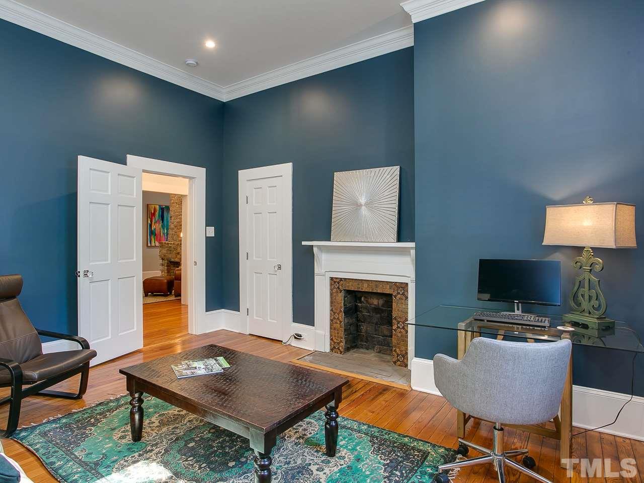 223 Elm Street Raleigh, NC 27601 - Photo 8 of 30 a living room with furniture a flat screen tv and a fireplace