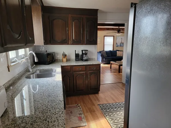 a kitchen with granite countertop a stove a sink and a microwave