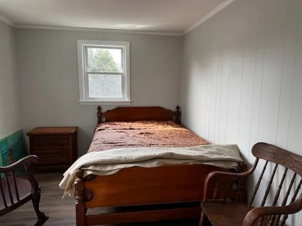 a bedroom with a bed chair and window