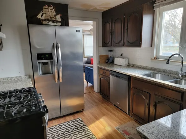 a kitchen with stainless steel appliances granite countertop a refrigerator a sink a stove and dishwasher