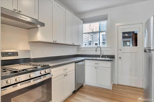 a kitchen with granite countertop cabinets stainless steel appliances and a window