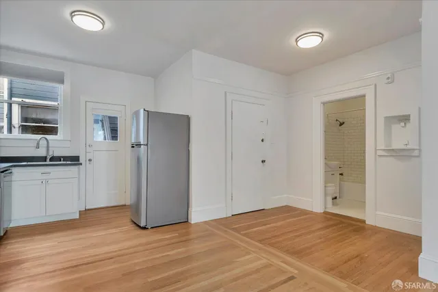 a view of a kitchen with a sink and a refrigerator