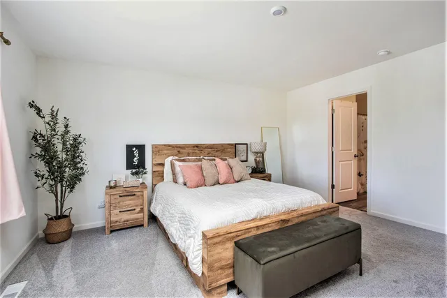 a bedroom with a bed and a potted plant