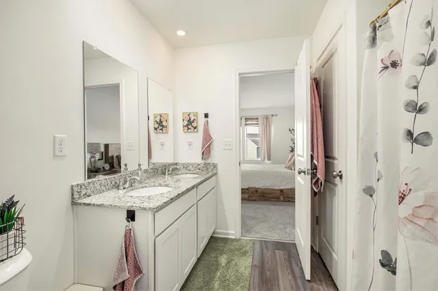 a en suite bathroom with a granite countertop sink and a mirror