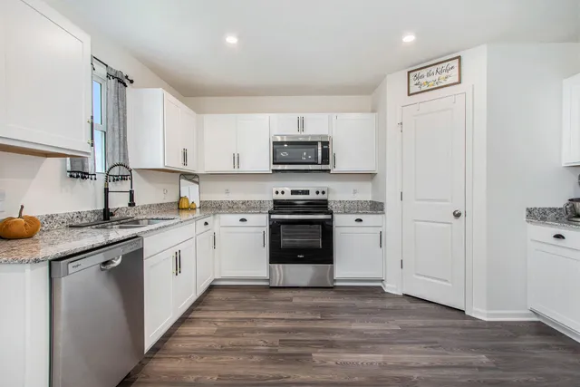 a kitchen with stainless steel appliances granite countertop a stove a sink and a refrigerator