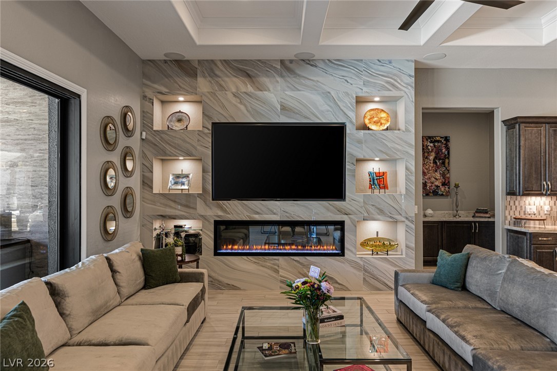 10118 Copper Edge Road Las Vegas, NV 89148 - Photo 6 of 48 A sophisticated living area features a grand marble-tiled wall with a contemporary fireplace and integrated display niches.