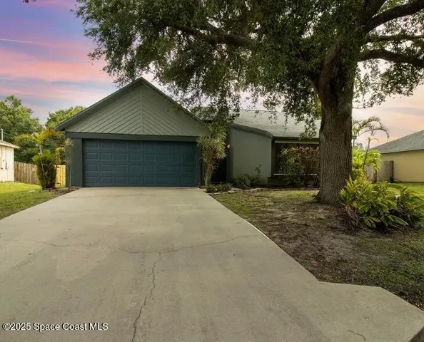 front view of a house with a yard and an trees