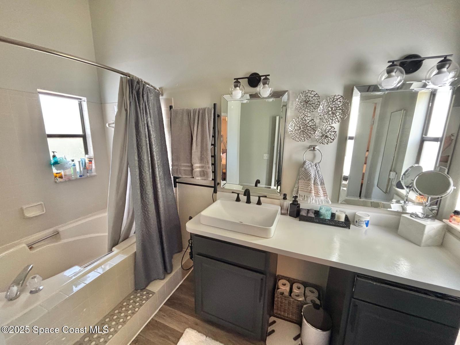 1626 Lara Street Northeast Palm Bay, FL 32907 - Photo 6 of 11 a bathroom with a double vanity sink a tub and a mirror