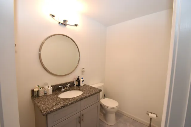 a bathroom with a granite countertop sink and a mirror