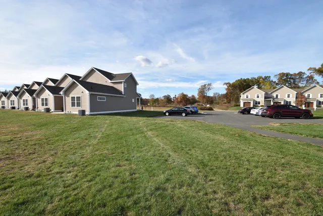 a view of a house with a big yard and large trees