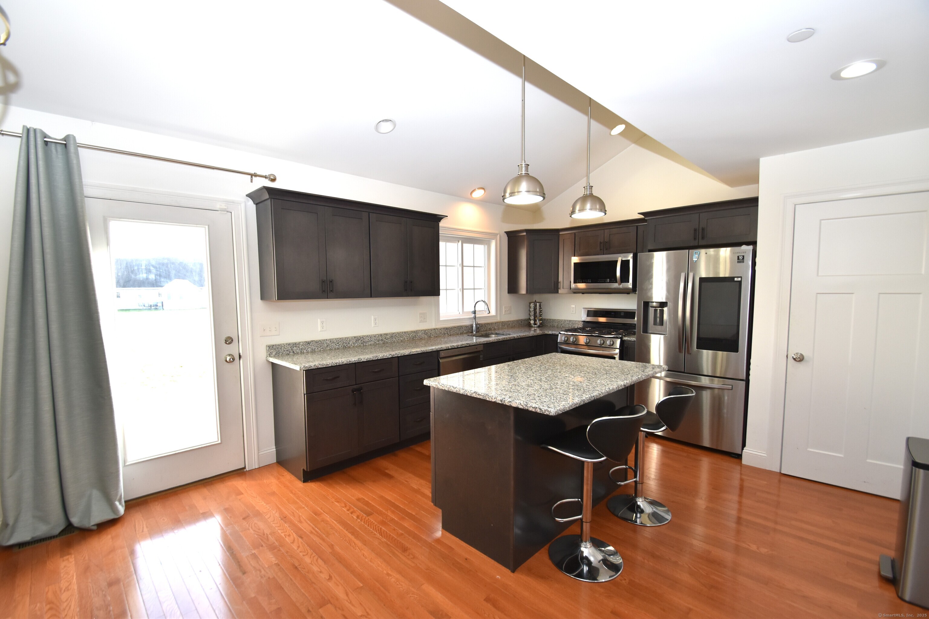 501 Old Village Circle Windsor, CT 06095 - Photo 6 of 16 a kitchen with stainless steel appliances granite countertop a refrigerator a stove a sink dishwasher and microwave with wooden floor