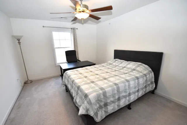 a bed sitting in a bedroom next to a window