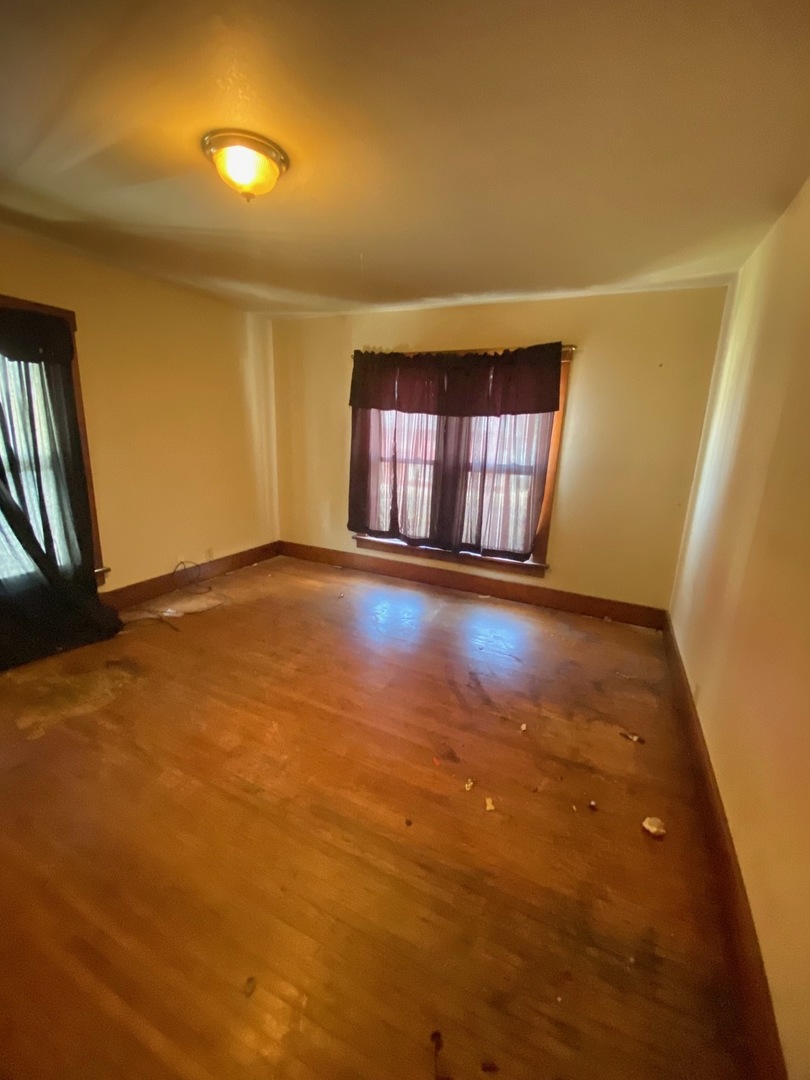 330 West Everett Street Dixon, IL 61021 - Photo 8 of 34 an empty room with wooden floor and windows