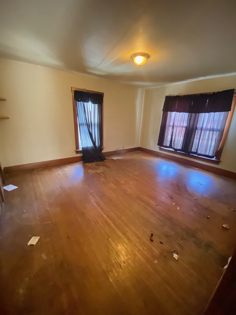 330 West Everett Street Dixon, IL 61021 - Photo 9 of 34 an empty room with wooden floor and windows
