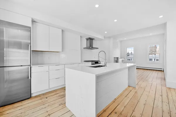 a kitchen with kitchen island a sink appliances and cabinets