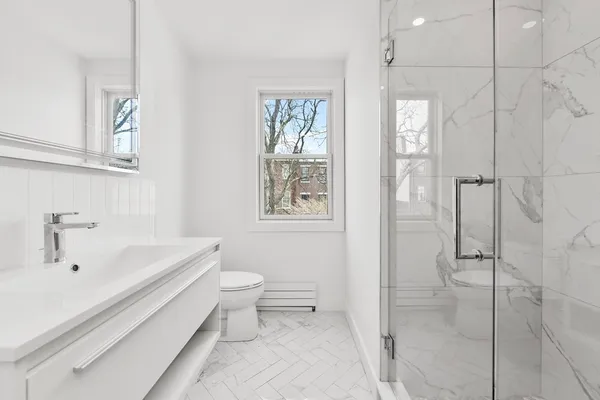 a bathroom with a toilet a sink a mirror and vanity