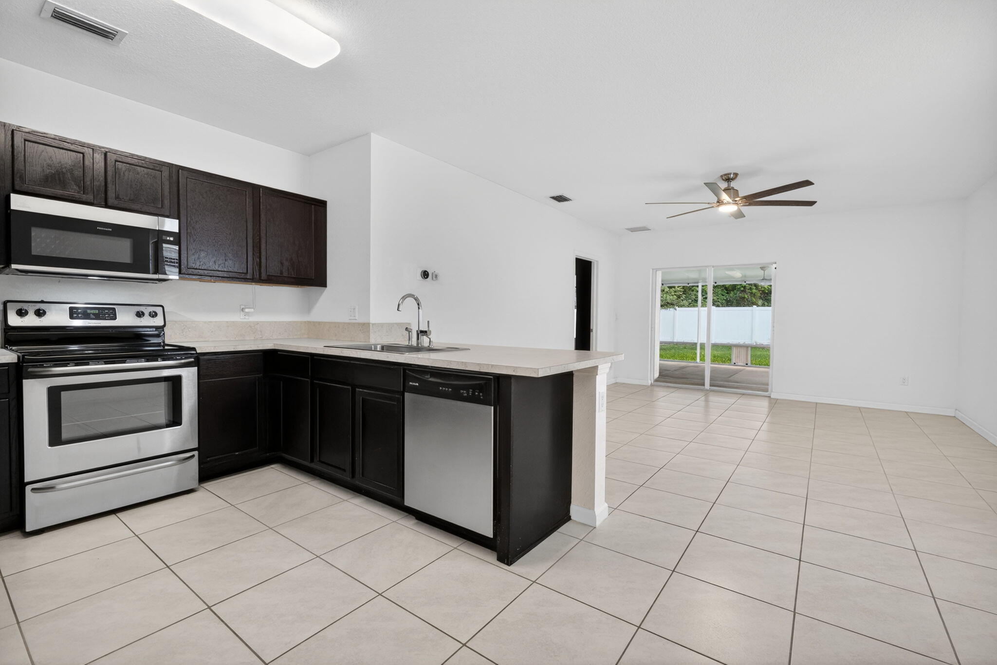 6814 Mitchell Street Jupiter, FL 33458 - Photo 15 of 49 a kitchen with stainless steel appliances granite countertop a stove a sink and a microwave