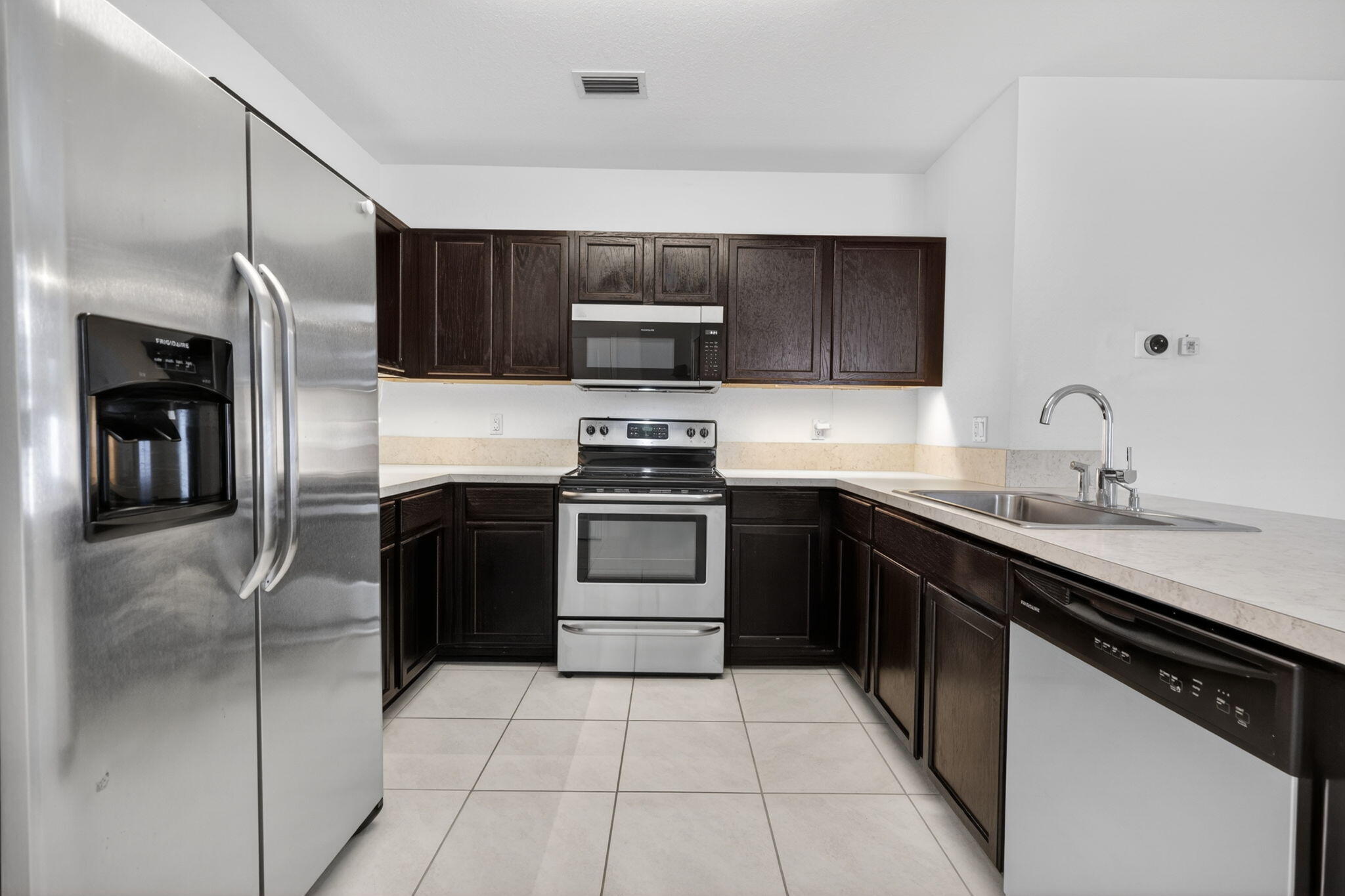 6814 Mitchell Street Jupiter, FL 33458 - Photo 17 of 49 a kitchen with a sink and stainless steel appliances