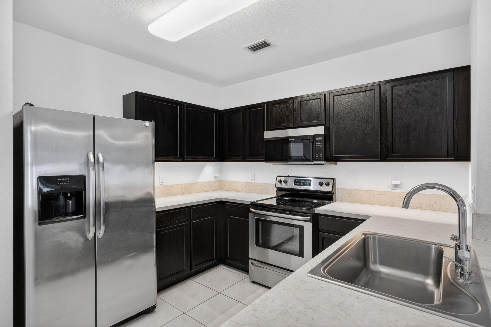 6814 Mitchell Street Jupiter, FL 33458 - Photo 18 of 49 a kitchen with granite countertop a refrigerator and a sink