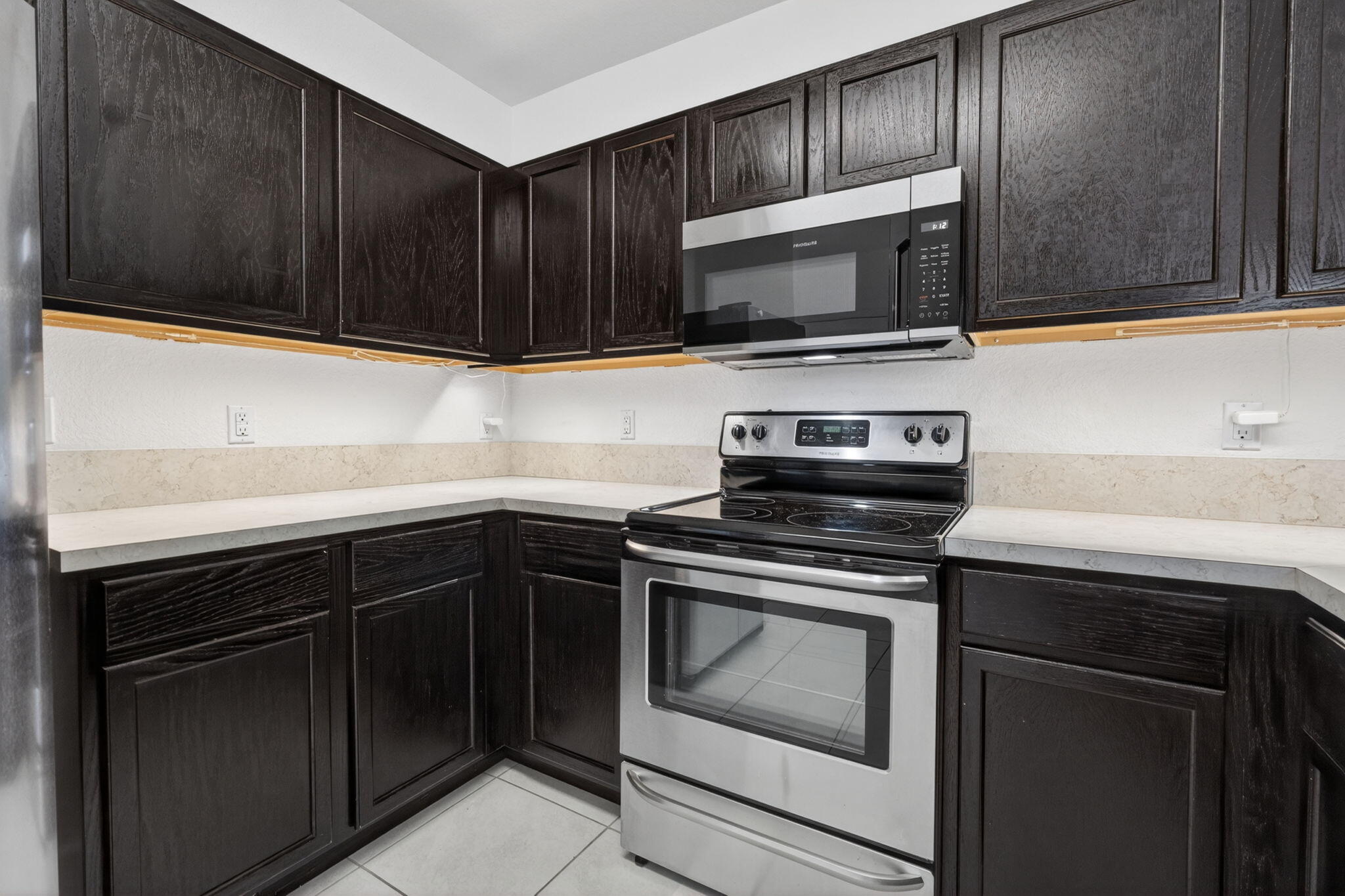 6814 Mitchell Street Jupiter, FL 33458 - Photo 19 of 49 a kitchen with granite countertop wood cabinets and stainless steel appliances